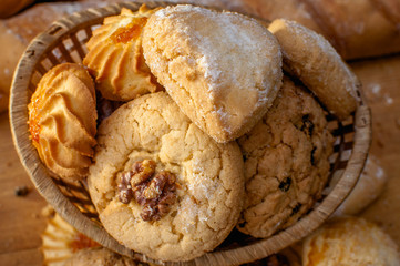 Freshly baked cookies and sweet pastries in the basket on wooden table