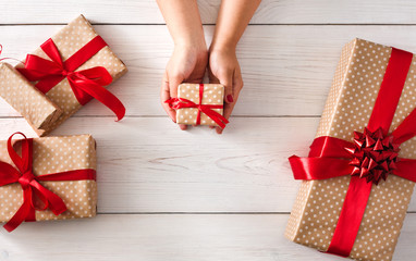 Woman's hands give christmas gift in present box