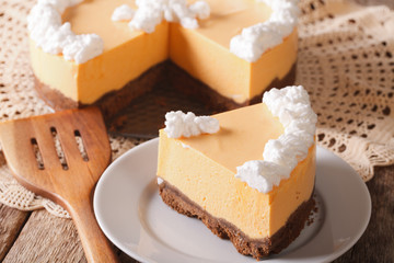 Fototapeta na wymiar piece of pumpkin cheesecake with whipped cream close-up on a plate. horizontal 