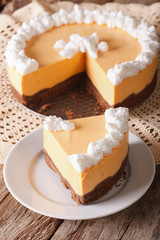 Cut pumpkin cheese cake decorated with whipped cream close-up. vertical
