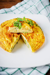 Omelet with vegetables in white ceramic plate