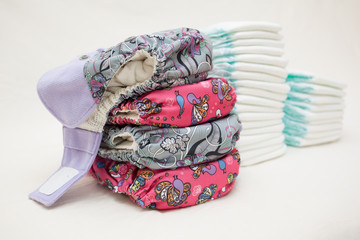 Stacks of disposable diapers and modern cloth diapers