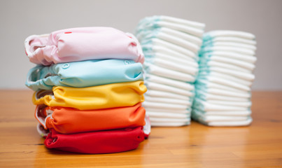 Stacks of disposable diapers and modern cloth diapers