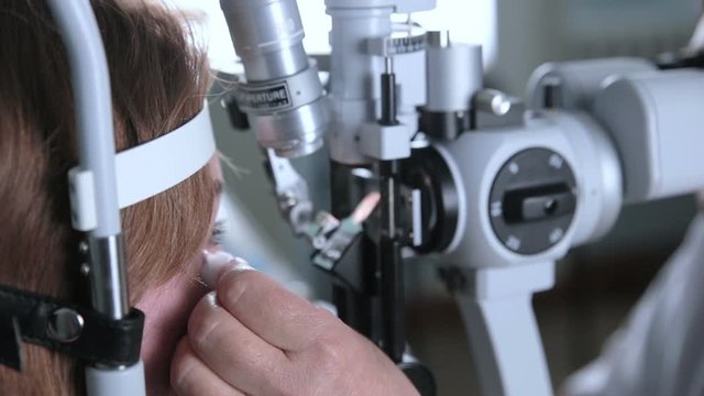 Ophthalmologist checks woman's eyes. HD