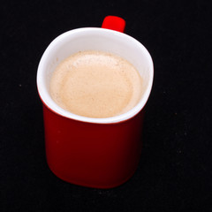 Red cup of coffee on black background