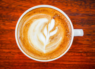 Latte Coffee art on the wooden table .