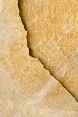 Yellow stone surface with a crack