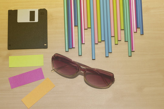 office desk group of pencil,diskette,orange note,lens,small note on wooden desk,colorful of pencil on wooden desk