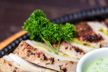 Grilled chicken breast in different variations with cherry tomatoes, green French beans, garlic, herbs, cut lemon on a wooden board or teflon pan. Traditional cuisine. Grill kitchen.