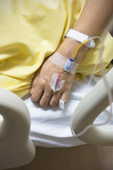 Asian woman patient is on drip receiving a saline solution on be