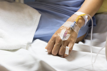 Asian woman patient is on drip receiving a saline solution on be