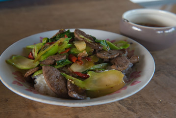 Fried kale with pork liver. Thai food on wood Background