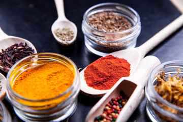 Spices on black background in special jars. Food
