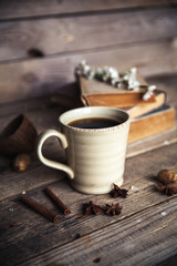 Large Cup of coffee on vintage wooden background. Spring flowers and books.
