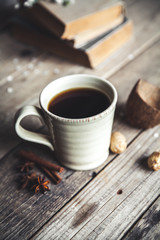 Large Cup of coffee on vintage wooden background. Spring flowers and books.