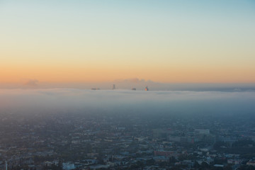 夜明け、霧に包まれるDowntown LA / 日の出直後の朝陽を受ける高層ビルです。