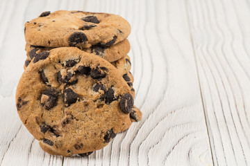 Chocolate cookies closeup on white old wooden table.