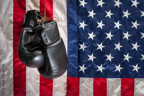 “Boxing gloves hanging in dramatic light against the american flag in