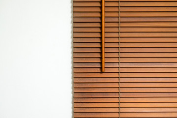 Dirty wooden blinds with white concrete background.