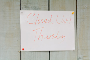 Closed Until Thursday sign outside shop