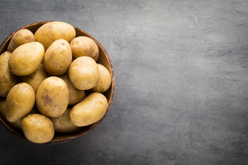 New potato on the bowl, gray background.