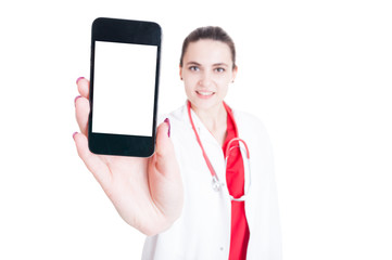 Pretty woman doctor showing smartphone with empty screen