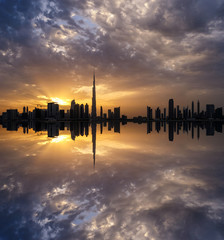 Obraz premium Fascinating reflection of tallest skyscrapers in Business Bay district during dramatic sunset. Downtown summer day. Construction built at evening time. Dubai, United Arab Emirates.