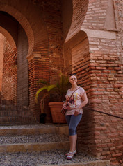 Fototapeta na wymiar Woman standing on the staircase of the Alcazaba fortress in Almeria, Spain 