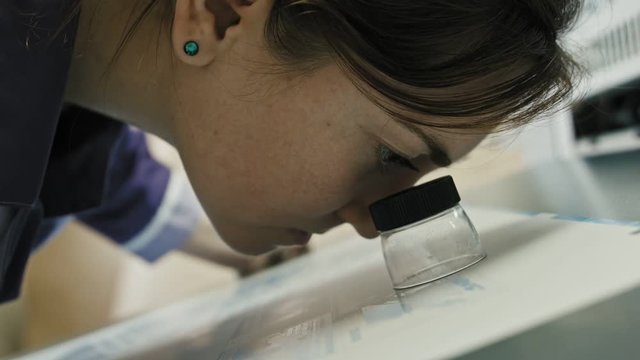industrial printing process - worker monitors print quality, close up