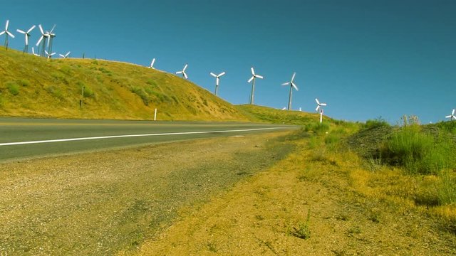A wide angle view of a wind farm along a road near Tehachapi, CA.