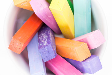 Square colorful pastel chalks tops closeup, on white background