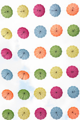 A lot of neatly arranged umbrellas are hung in the sky,