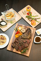 Deboned tomahawk rib steak with pepper sauce served with gratina