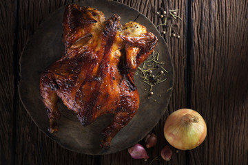 Roasted chicken on wooden cutting board.