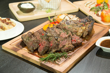 Deboned tomahawk rib steak with pepper sauce served with gratina