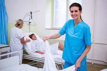 Obraz premium Nurse preparing a bed for a patient