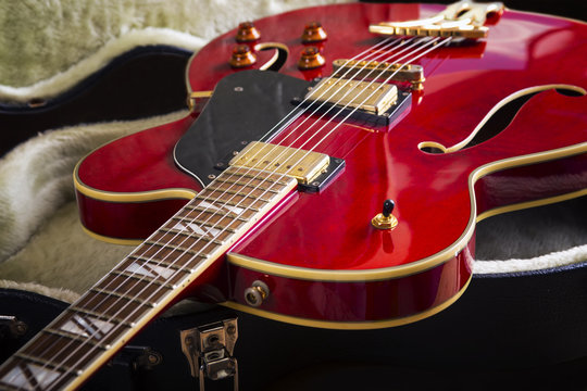 Red acoustic guitar close up in dark background