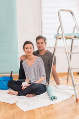  couple wallpapering their new flat take a break with a coffee