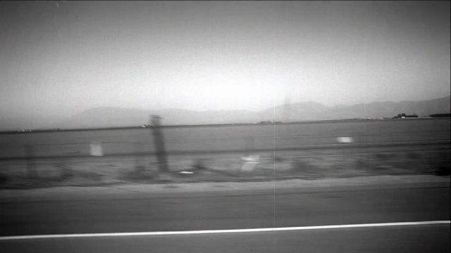 A vintage styled view out of the car traveling down the interstate.