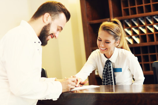 Man signing bill in hotel