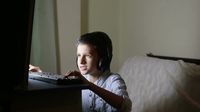 Teen boy plays games on the computer at night. Online Games