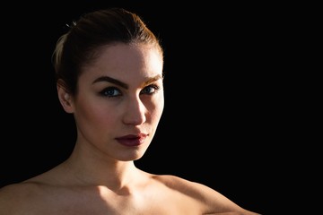 Portrait of beautiful woman posing against black background