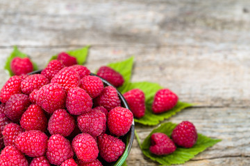Delicious raspberry in a bowl on wooden background