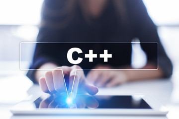 Woman is using tablet pc, pressing on virtual screen and selecting "C++".