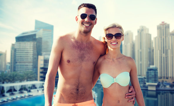 happy couple in swimwear over dubai city waterside