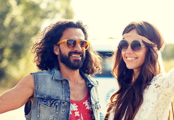 smiling young hippie couple over minivan car