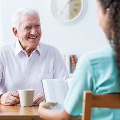 Retiree and nurse reading book