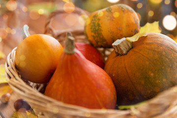 close up of pumpkins in basket on wooden table