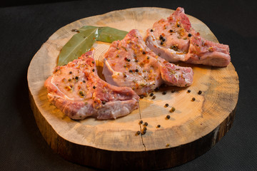 Raw pork ribs with spices, salt and rosemary on dark wooden background