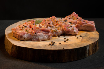 Raw pork ribs with spices, salt and rosemary on dark wooden background